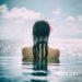 Woman tourist in infinity pool of hotel resort at ocean