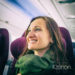 Happy woman tourist with green scarf during flight in plane to her vacation
