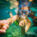 Snorkelling woman in yellow bikini makes tempting gesture in ocean